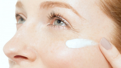 Femme s'appliquant de la crème sur le visage